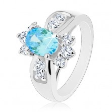 Ring with shiny widened shoulders, coloured oval zircon, round clear zircons